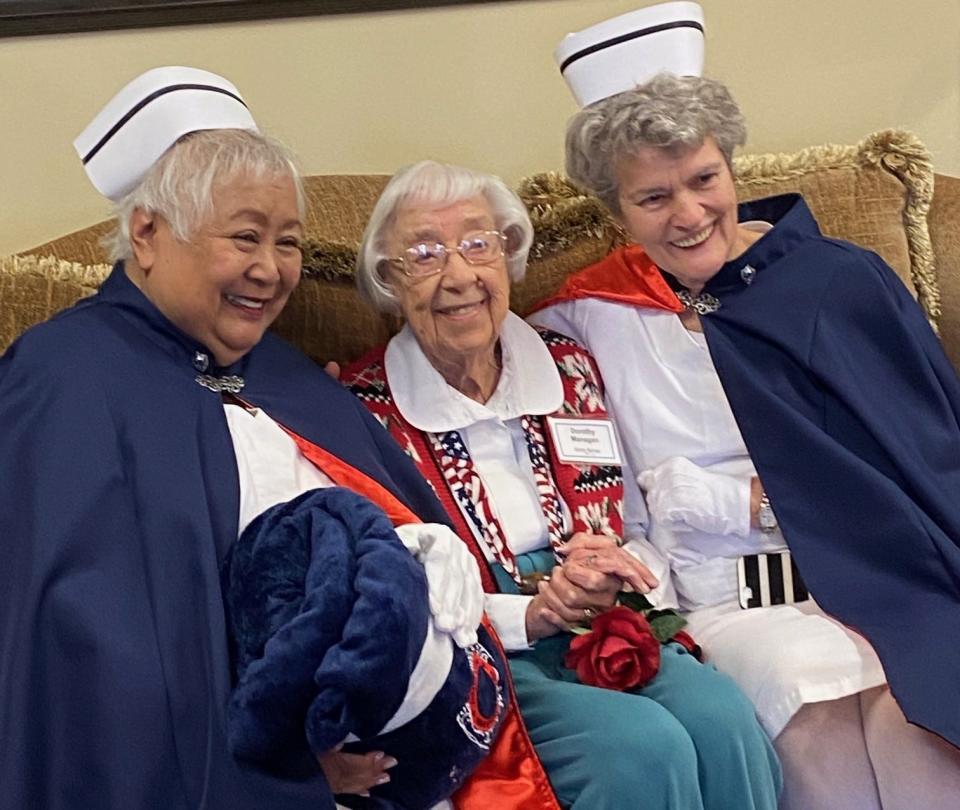 Dorothy Managan, center, receives a comfort blanket from Cecilia Neira (at left).