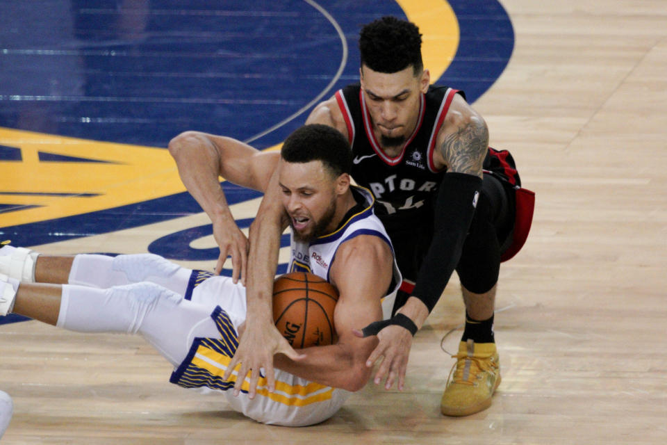 Toronto Raptors guard Danny Green, top, reaches over Golden State Warriors guard Stephen Curry during the second half of Game 3 of basketball's NBA Finals in Oakland, Calif., Wednesday, June 5, 2019. (AP Photo/Tony Avelar)