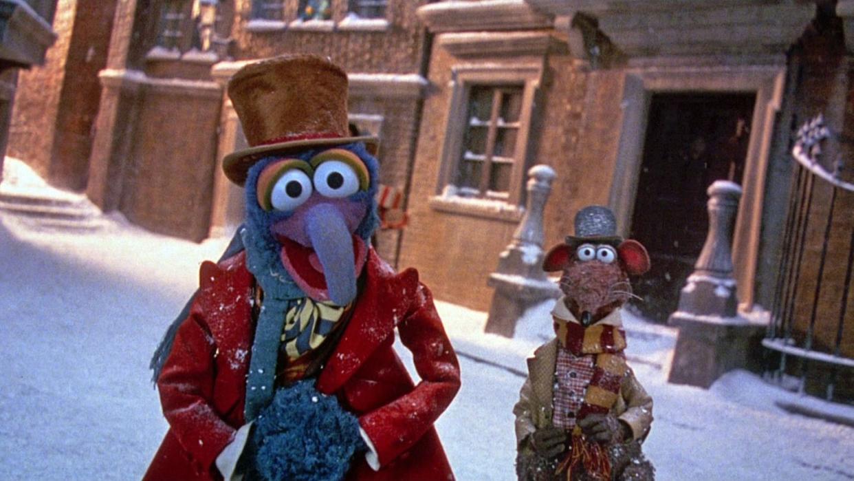 gonzo and rizzo stand in festive garb in a scene from the muppet christmas carol, a good housekeeping pick for best christmas movies for kids