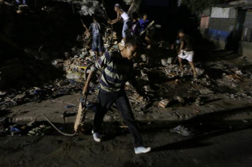 Un muchacho recoge material reciclable de los escombros de una casa destruida por un terremoto, el pasado 11 de abril en Managua (AFP/Archivos | Inti Ocon)