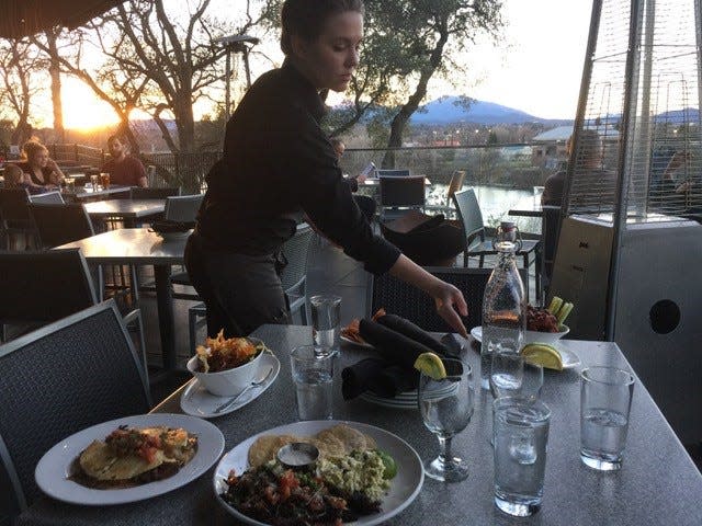 File photo - In 2018, server Kenzie Moore puts the final touches on the table during half-price "mid day menu" appetizers at View 202 in Redding.