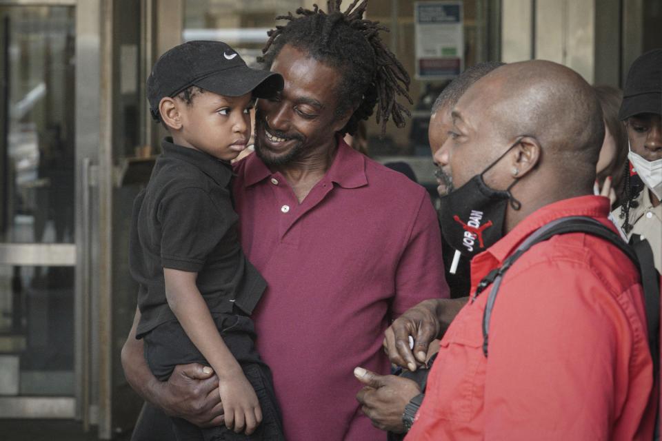 James Irons, center, holds his grand nephew Michael, 5, as he leaves Brooklyn Supreme Court following his exoneration, Friday July 15, 2022, in New York. (AP Photo/Bebeto Matthews)