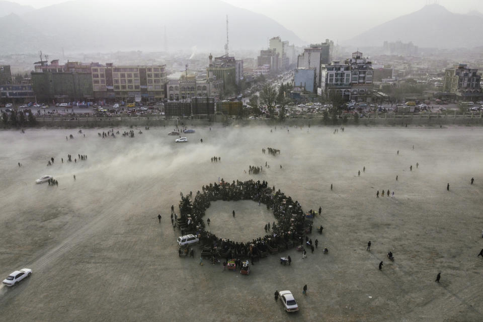 An aerial view of Chaman-e-Huzori park downtown Kabul Afghanistan, as people make a circle to watch wrestling matches , Friday, Dec. 3 , 2021. The scene is one played out each week after Friday prayers in the sprawling Chaman-e-Huzori park in downtown Kabul, where men, mainly from Afghanistan's northern provinces, gather to watch and to compete in pahlawani, a traditional form of wrestling. (AP Photo/ Mstyslav Chernov)
