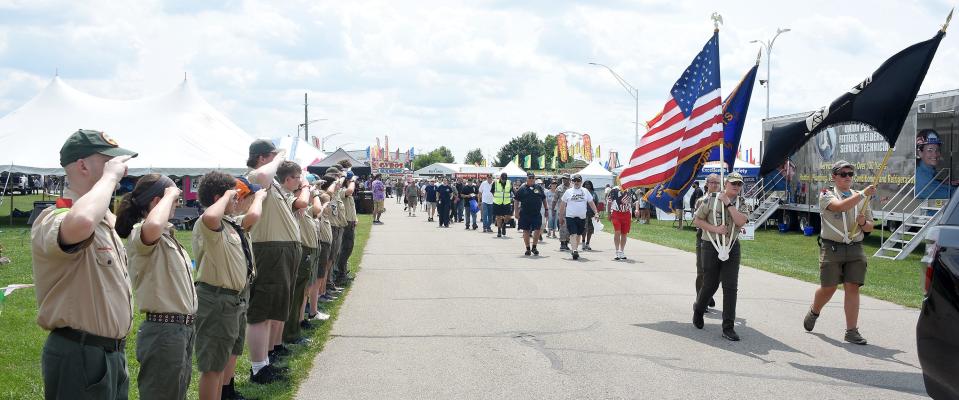 Boy Scout Troop 1948 salutes the veterans as they parade around the Monroe County Fairgrounds. Ray Spor carried the American flag, Zach Krabach carried the AMVETS flag, and Tiernan Strimple carried the POW flag before Monday's Veterans Day program at the fair.
