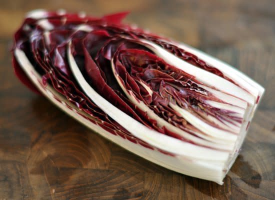 Radicchio is Italian in origin. The lettuce is characterized by dark red leaves with bright white stems on a tightly packed head. The taste is bitter. Radicchio comes in two main varieties, the small cabbage-like Chioggia and oblong Treviso. Radicchio is great in mixed salads and also works well grilled.    Photo from <a href="http://www.flickr.com/photos/cyclonebill/5680915288/" target="_hplink">cyclonebill, Flickr</a>.