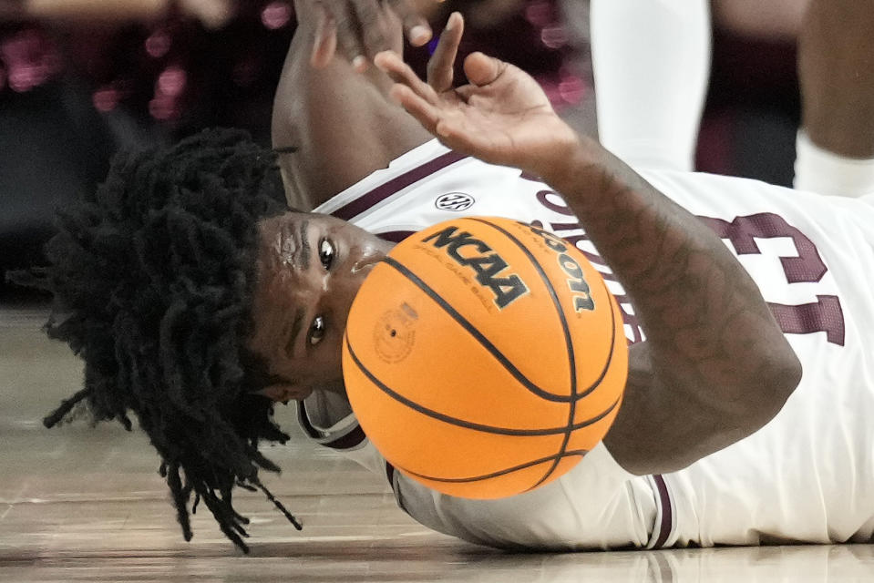 Texas A&M forward Solomon Washington (13) dives for a loose ball against Memphis during the first half of an NCAA college basketball game, Sunday, Dec. 10, 2023, in College Station, Texas. (AP Photo/Sam Craft)