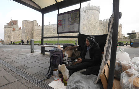 Stuart, a homeless man, sits under a bus shelter where he sleeps opposite Windsor Castle in Windsor, Britain, January 4, 2018. REUTERS/Toby Melville