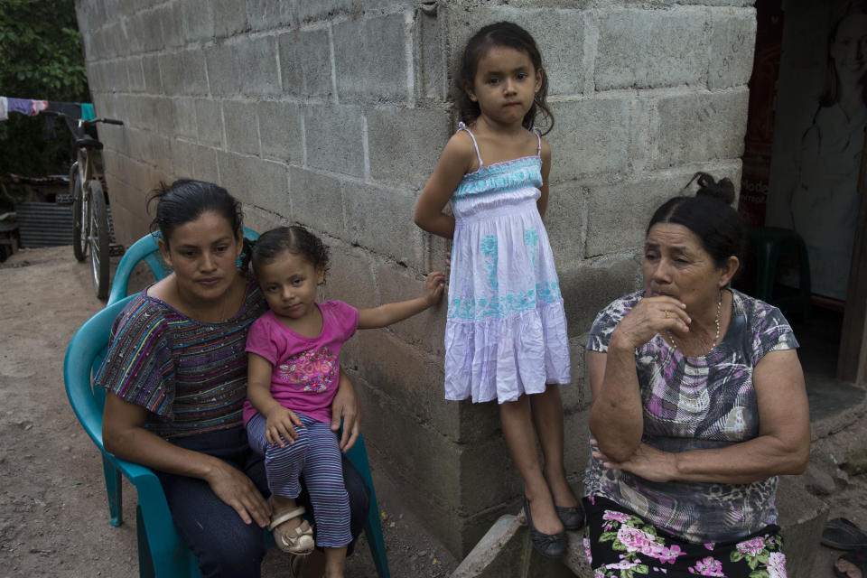 En esta foto del 2 de noviembre de 2018, Deysi Orellana, de izquierda a derecha, Brithani Lizeth, de 3 años, Janeisy Nicolle, de 5 años, y Evangelina Murillo, se reúnen fuera de su hogar durante una entrevista en San Pedro Sula, Honduras. (AP Foto / Moises Castillo)