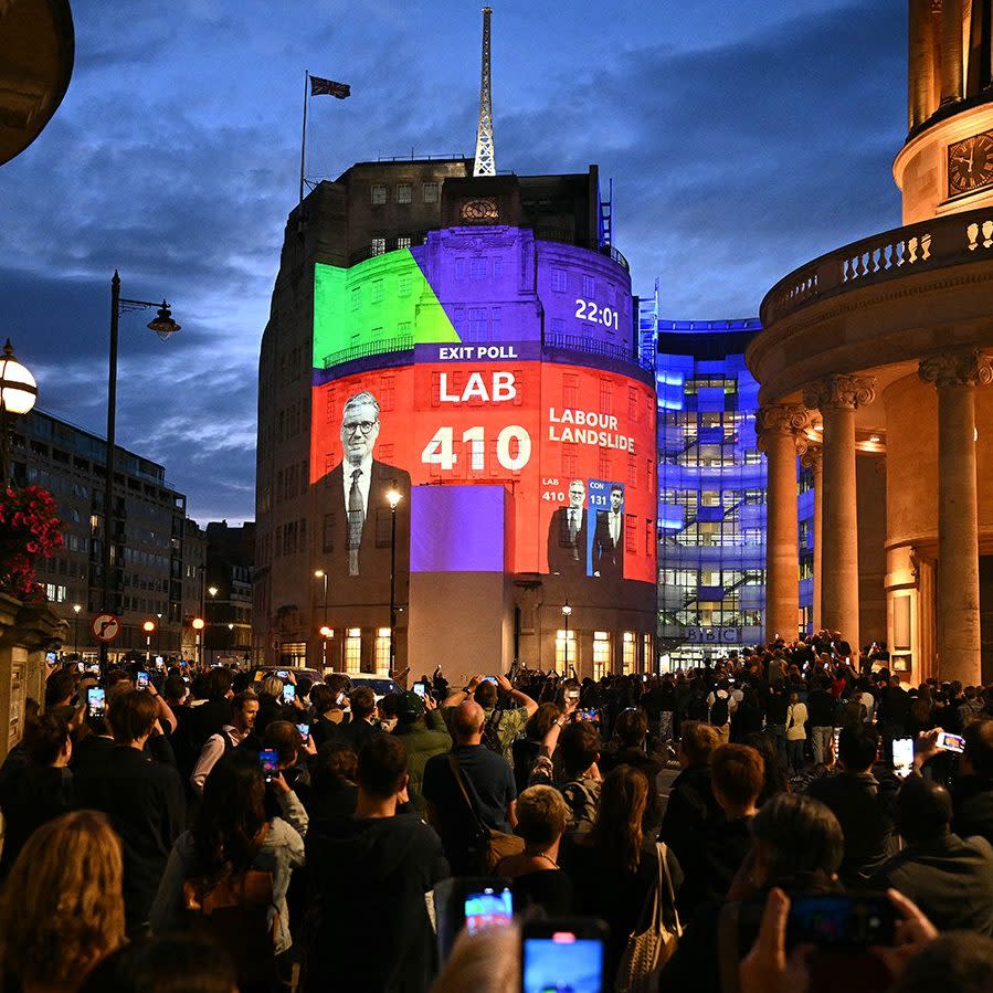 People watch the exit poll results projected onto the front of the BBC office in central London