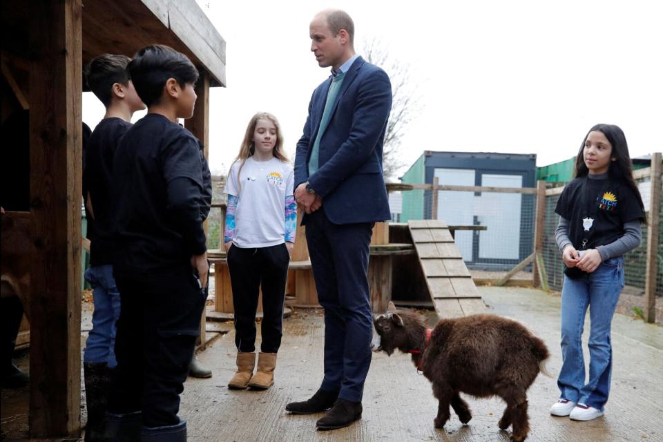 Prince William, Duke of Cambridge (C) speaks with children during his visit to CATCH