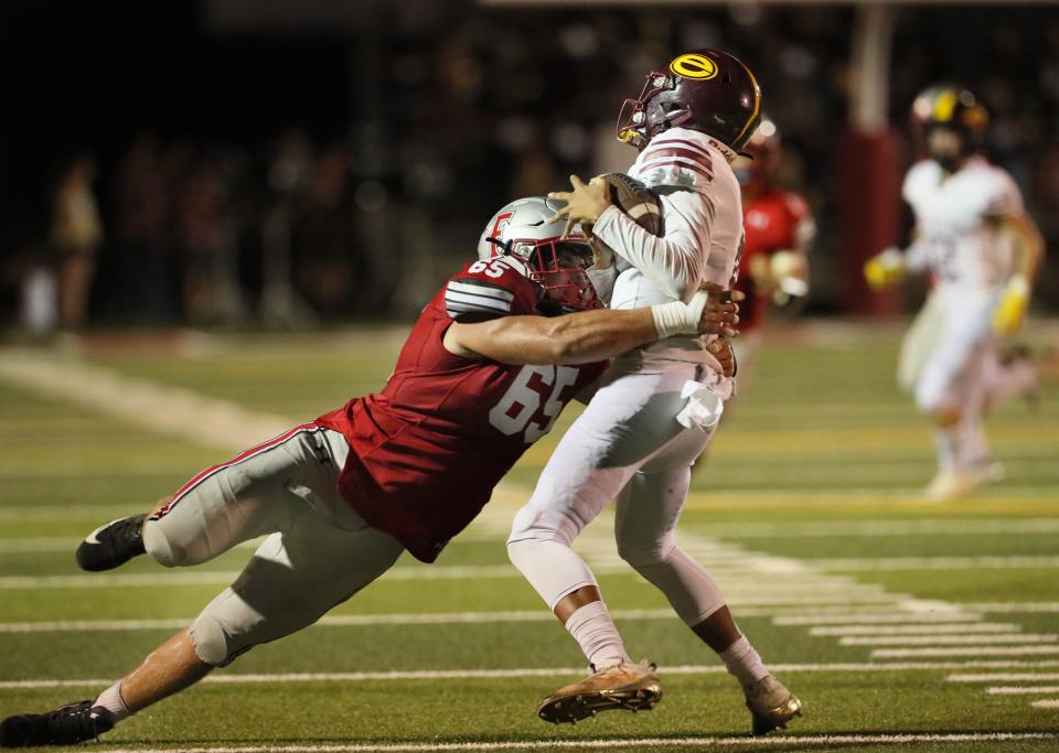 Foothill senior Dylan Labarbera (left) wraps his arms around Stockton freshman quarterback Berell Staples (right) on Friday, Aug. 26, 2022 during their schools' football game in Palo Cedro, California.