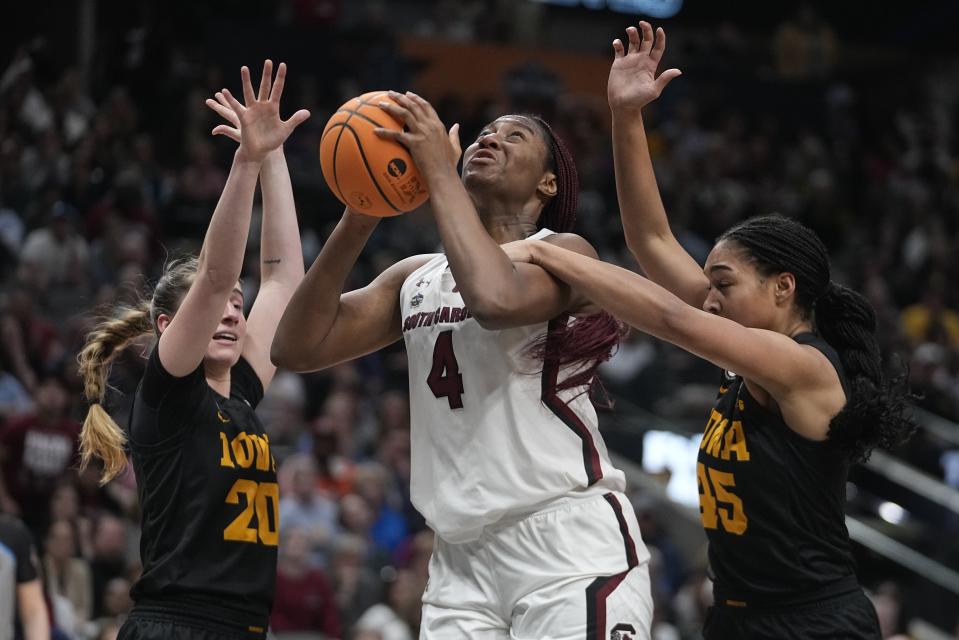 South Carolina's Ashlyn Watkins is fouled as she shoots against Iowa's Hannah Stuelke and Kate Martin during the second half of an NCAA Women's Final Four semifinals basketball game Friday, March 31, 2023, in Dallas. (AP Photo/Darron Cummings)