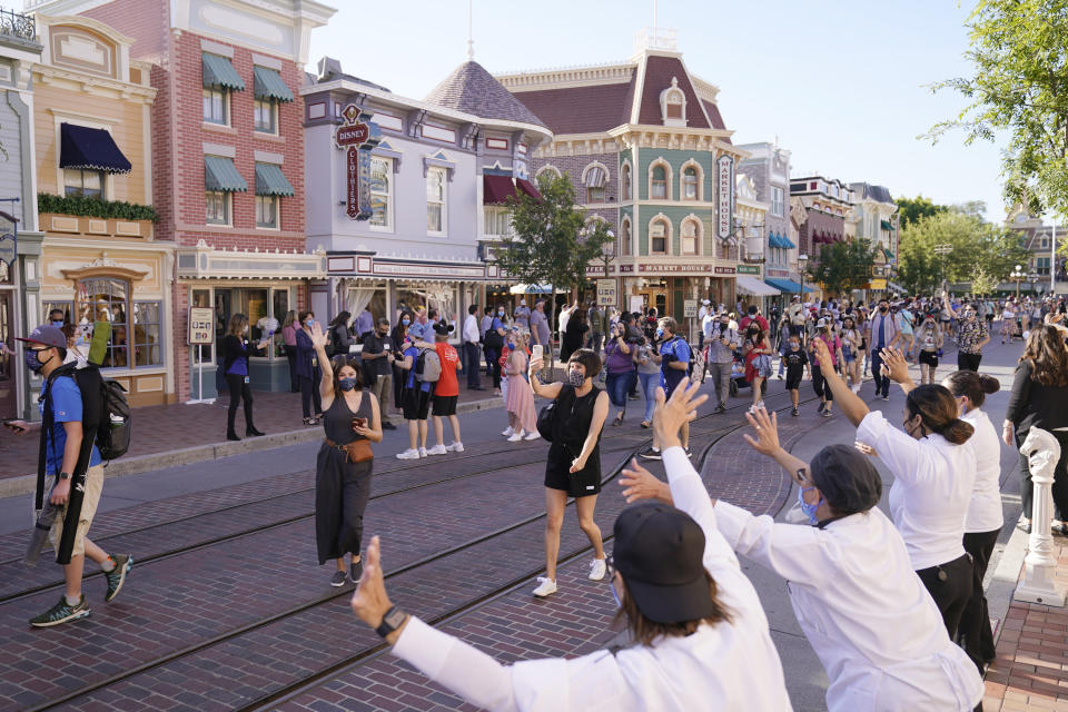 FILE - In this Friday, April 30, 2021, file photo, guests walk down Main Street USA at Disneyland in Anaheim, Calif. California's top health official says the state will no longer require social distancing and will allow full capacity for businesses when the state reopens on June 15. State health director Dr. Mark Ghaly said Friday, May 21, 2021, that dramatically lower virus cases and increasing vaccinations mean it's safe for the state to remove nearly all restrictions next month. (AP Photo/Jae Hong, File)