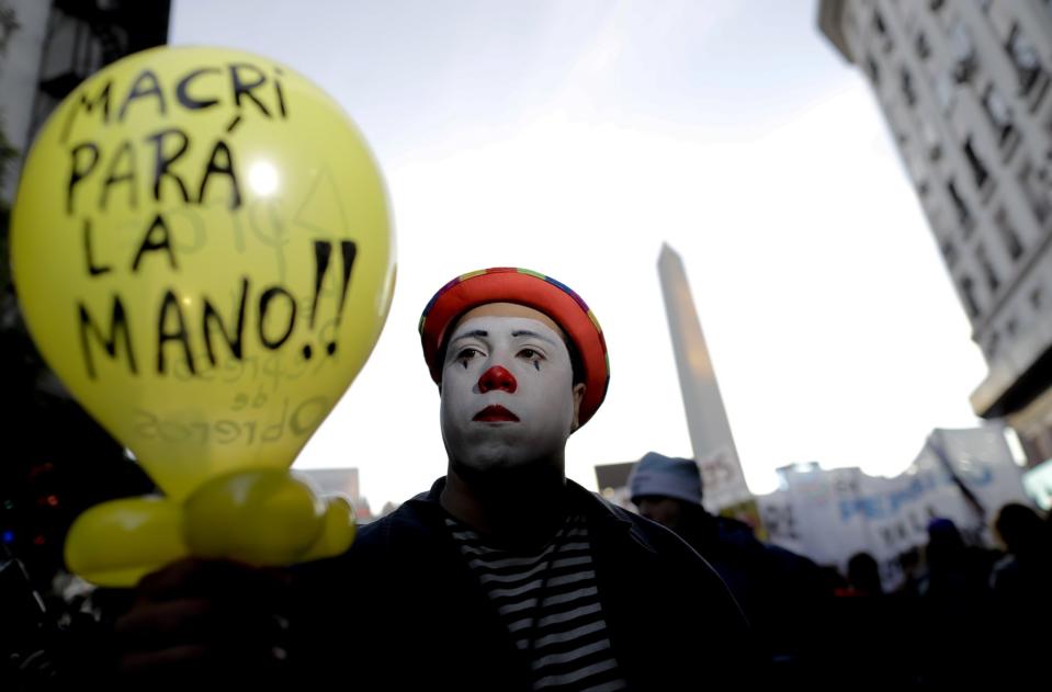 <p>Ein als Clown verkleideter Demonstrant hält auf den Straßen von Buenos Aires einen Luftballon hoch, auf dem geschrieben steht: „Macri, nimm‘s nicht schwer“. Damit ist der amtierende Staatspräsident Mauricio Macri gemeint, unter dem die Arbeitslosigkeit in dem südamerikanischen Land in letzter Zeit drastisch anstieg. Der aktuelle Protest formierte sich, nachdem eine Fabrik von Pepsi geschlossen werden soll, wodurch 600 Arbeiter ihre Jobs verlieren. (Bild: AP Photo/Natacha Pisarenko) </p>
