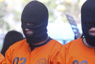 A British national, left, detained for drugs charges is displayed during a news conference during in Bali, Indonesia on Friday, Aug. 5, 2022. Authorities in Indonesia arrested three foreigners, for distributing cocaine on the Indonesian resort island of Bali at the end of July. From the three suspects that are identified as British, Brazilian and Mexican, the officers from the National Narcotics Agency seized 844.59 gram (1.86 pounds) of cocaine with other drugs, including MDMA and marijuana. (AP Photo/Firdia Lisnawati)