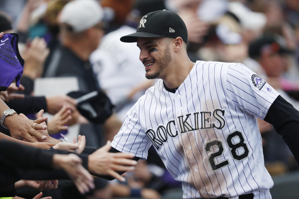 FILE - In this Sept. 30, 2018, file photo, fans congratulate Colorado Rockies third baseman Nolan Arenado after the Rockies defeated the Washington 12-0, in Denver. The sluggish free agent market the last two years has not scared off Colorado third baseman Nolan Arenado, who could be among the prizes in the 2020 pool. (AP Photo/David Zalubowski, File)