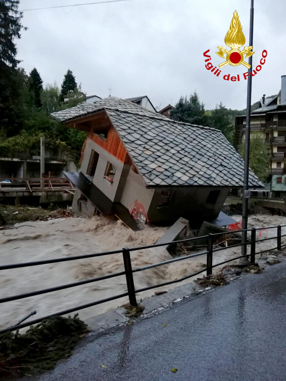A building is toppled over by the Cervo river in spate due to heavy rains in Biella, northern Italy, Saturday, Oct. 3, 2020. (Firefighter Vigili del Fuoco via AP)