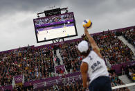 Spectators watch as Brazil's Emanuel serves against Poland's Mariusz Prudel and Grzegorz Fijalek during their men's quarterfinals beach volleyball match at Horse Guards Parade during the London 2012 Olympic Games August 6, 2012. REUTERS/Marcelo del Pozo (BRITAIN - Tags: OLYMPICS SPORT VOLLEYBALL) 