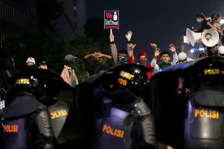 Protester holds a placard during a protest across the Election Supervisory Agency (Bawaslu) headquarters following the announcement of the last month's presidential election results in Jakarta, Indonesia, May 22, 2019. REUTERS/Willy Kurniawan