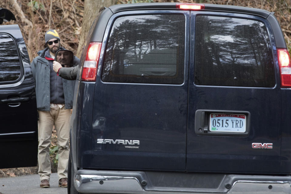 A man driving a van with diplomatic license plates hands his identification to U.S. special agents outside an estate in the village of Upper Brookville in the town of Oyster Bay, N.Y., on Long Island on Friday, Dec. 30, 2016. On Friday, the Obama administration closed this compound for Russian diplomats, in retaliation for spying and cyber-meddling in the U.S. presidential election. (AP Photo/Alexander F. Yuan)
