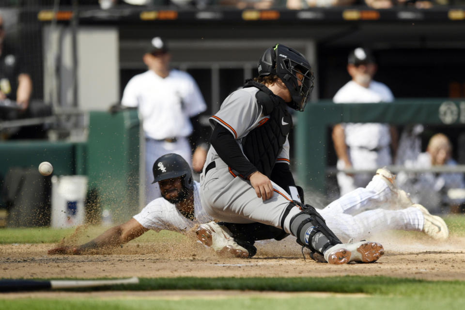 Chicago White Sox's Elvis Andrus slides into home plate safely on a double by Andrew Vaughn as Baltimore Orioles catcher James McCann can't make the tag during the seventh inning of a baseball game Saturday, April 15, 2023, in Chicago. (AP Photo/Paul Beaty)