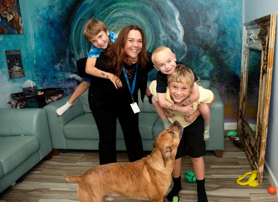 Riviera Beach residents Jessica Fairbanks, holding Keenan Jynella, 6, and Caedyn Jynella, 5, held by his brother Gavin Fairbanks, 9, find great comfort in their dog Zeus.