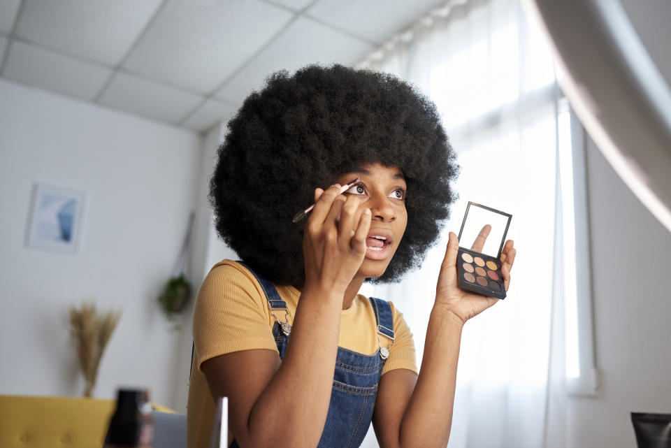 A woman applying makeup to her eye