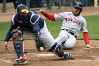 Boston Red Sox Christian Arroyo (39) slides safely into home base after Boston Red Sox Bobby Dalbec (29) hit a sharp line drive against the Minnesota Twins during the fifth inning of a baseball game, Tuesday, April 13, 2021, in Minneapolis. Boston won 4-2. (AP Photo/Stacy Bengs)