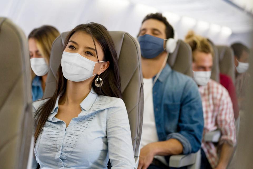 Woman traveling by plane wearing a facemask