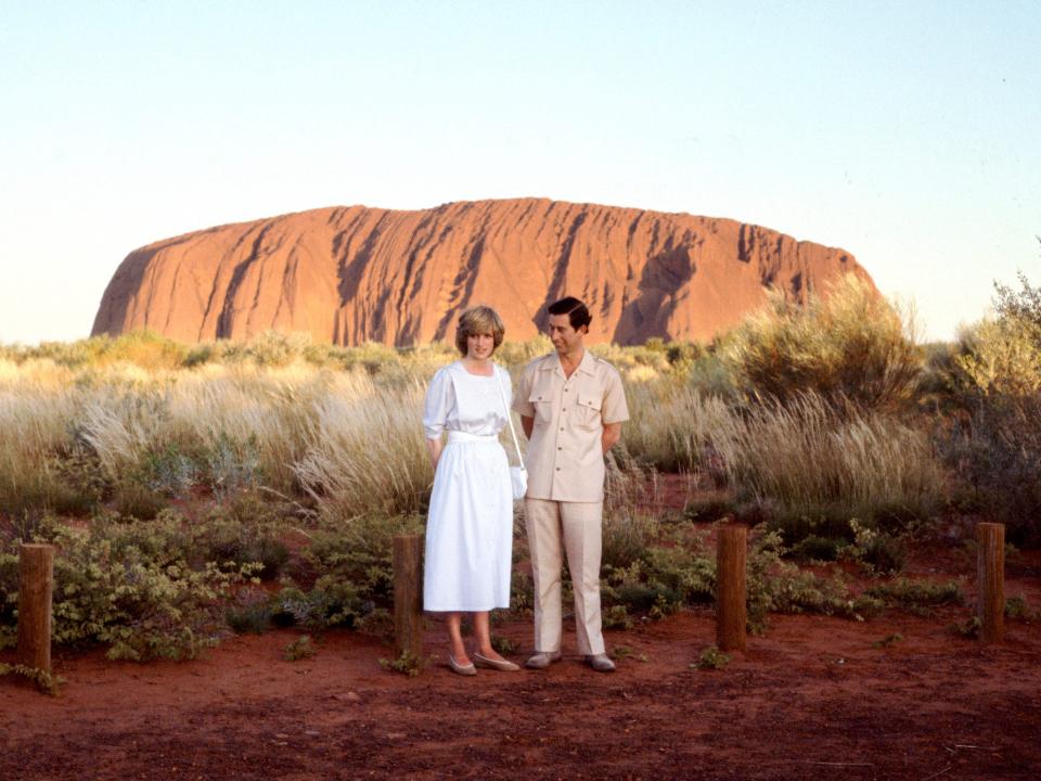 Prince Charles and Princess Diana standing in front of Ayers Rock during their official tour of Australia in 1983.