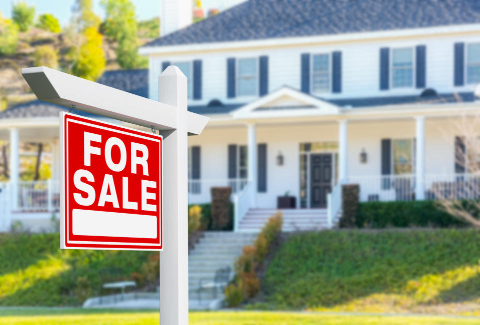 A "For Sale" sign in front of a house