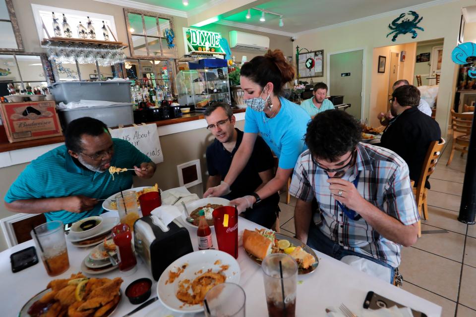 Waitress Gina Lauricella serves customers indoors for the first time since the state shutdown at Charles Seafood Restaurant in Harahan, La., on May 15, 2020.