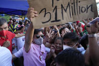 Presidential candidate Ferdinand "Bongbong" Marcos Jr. holds a sign he borrowed from the crowd as he celebrates outside his headquarters in Mandaluyong, Philippines on Wednesday, May 11, 2022. Ferdinand Marcos Jr., the namesake son of an ousted Philippine dictator, declared victory Wednesday in this week’s presidential election and faced early calls to ensure respect for human rights, the rule of law and democracy. (AP Photo/Aaron Favila)