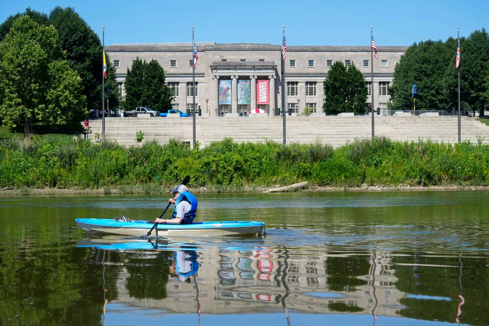 A kayaker on Wednesday floats past the launch area for the Red, White and Boom fireworks located behind COSI along the Scioto River in Columbus. Franklin County Sheriff's office and Columbus police and fire boats will close off the river to boat traffic between the two railroad bridges for the event on Friday.