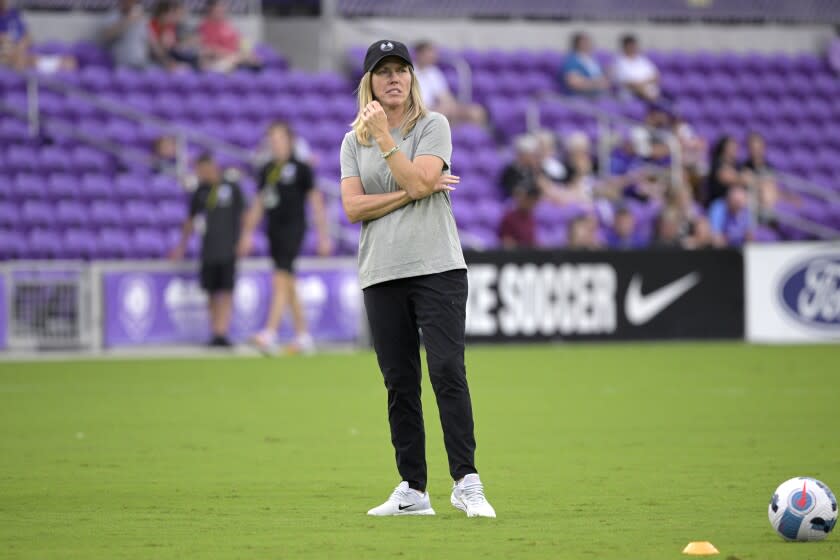 Orlando Pride head coach Amanda Cromwell watches players warm up before an NWSL Challenge Cup.