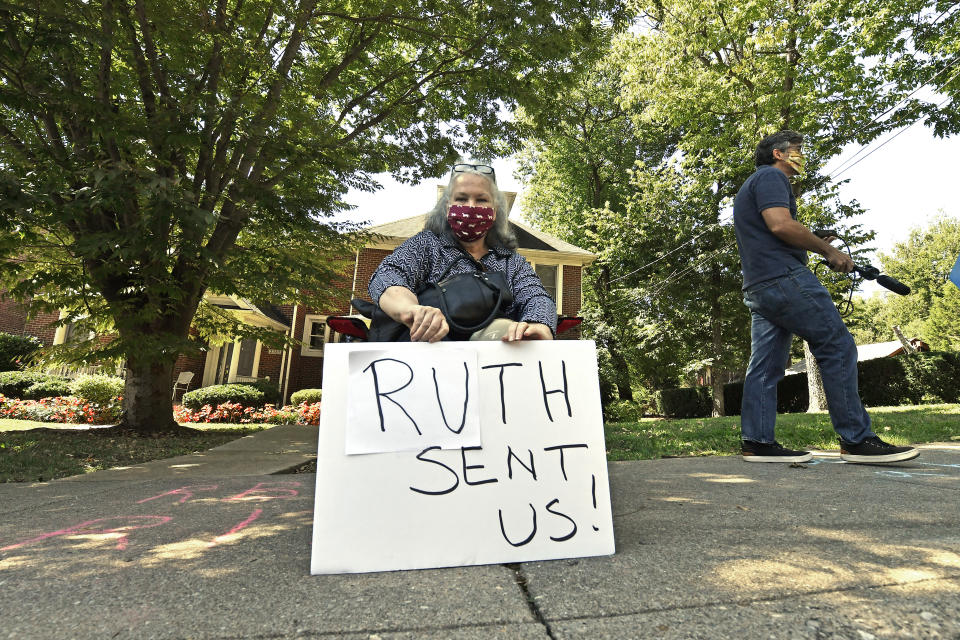 A protesters sits outside the house of Senate Majority Leader Mitch McConnell, R-Ky., in Louisville, Ky., Saturday, Sept. 19, 2020. McConnell vowed on Friday night, hours after the death of Supreme Court Justice Ruth Bader Ginsburg to call a vote for whomever President Donald Trump nominated as her replacement. (AP Photo/Timothy D. Easley)