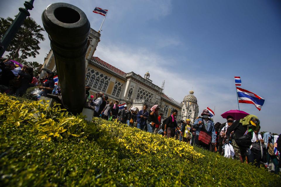 Anti-government protesters wave national flags after they entered the compound of Government House, the site of fierce clashes with police over the last few days, in Bangkok December 3, 2013. Thailand's government ordered police to stand down and allow protesters into state buildings on Tuesday, removing a flashpoint for clashes and effectively bringing an end to days of violence in Bangkok in which five people have died. REUTERS/Athit Perawongmetha