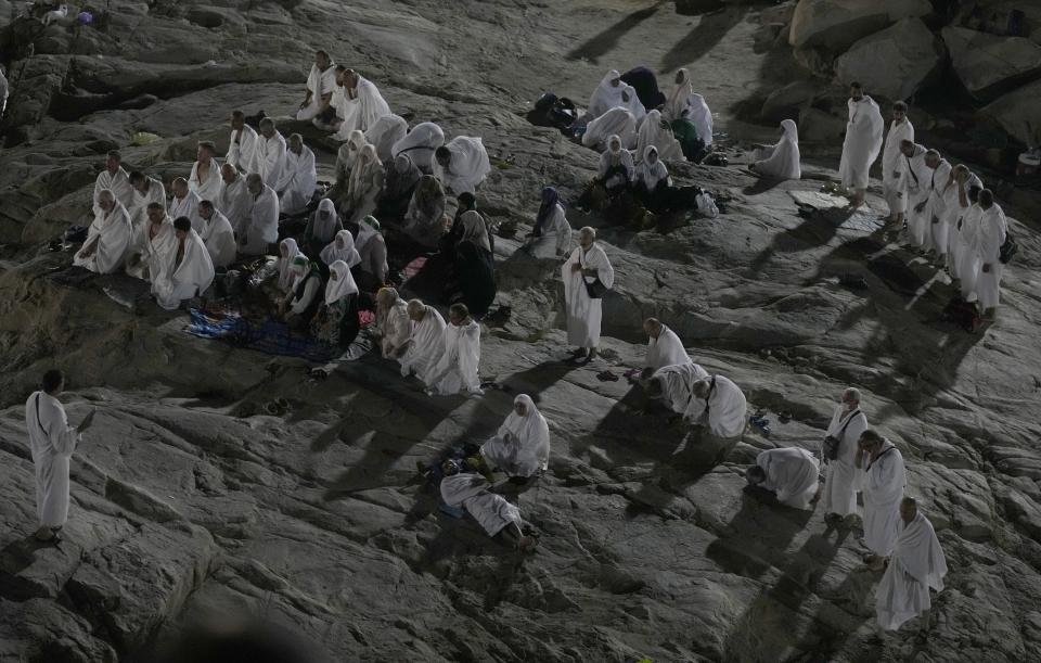 Muslim pilgrims pray on the rocky hill known as the Mountain of Mercy, on the Plain of Arafat, during the annual hajj pilgrimage, near the holy city of Mecca, Saudi Arabia, Friday, July 8, 2022. (AP Photo/Amr Nabil)