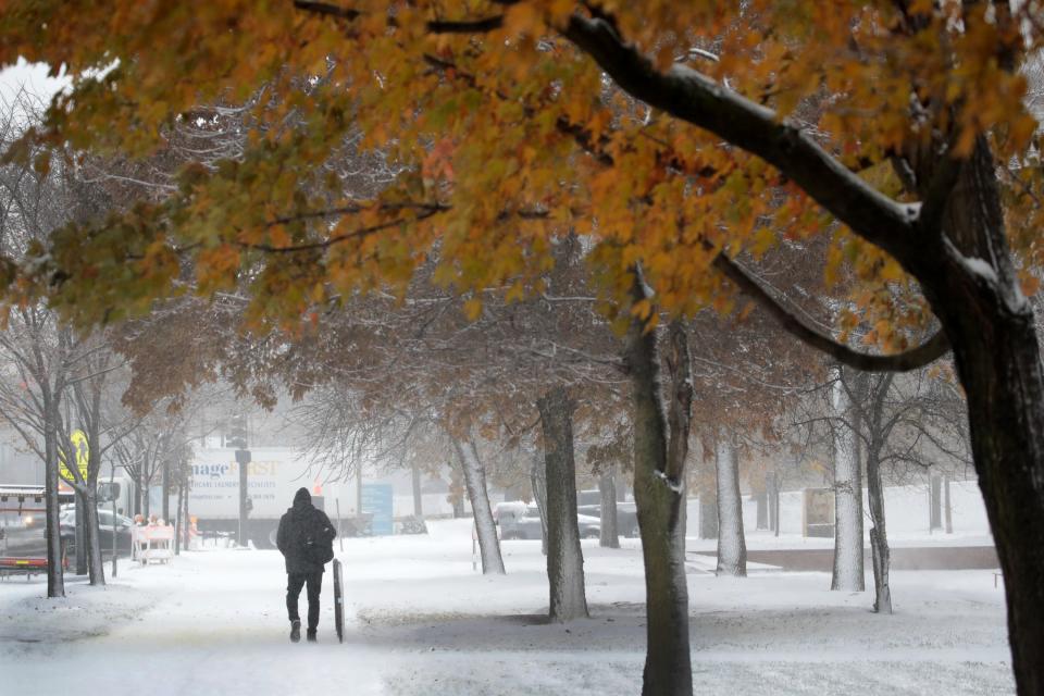 People navigate snow-covered sidewalks in the Humboldt Park neighborhood on November 11, 2019, in Chicago, Illinois. Forecasters are calling for three to six inches of snow to fall in the Chicago area by mid-day today and temperatures are expected to fall to around ten degrees by tomorrow.