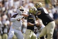 Colorado quarterback Drew Carter, front, runs for a short gain as offensive lineman Gerad Christian-Lichtenhan, back right, tangles with Minnesota defensive lineman Boye Mafe in the second half of an NCAA college football game Saturday, Sept. 18, 2021, in Boulder, Colo. Minnesota won 30-0. (AP Photo/David Zalubowski)