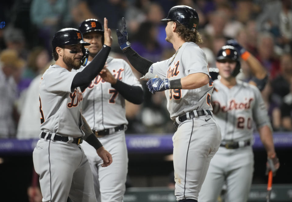 Detroit Tigers' Zach McKinstry, right, is congratulated as he crosses home plate on a three-run home run during the 10th inning of the team's baseball game against the Colorado Rockies on Saturday, July 1, 2023, in Denver. (AP Photo/David Zalubowski)