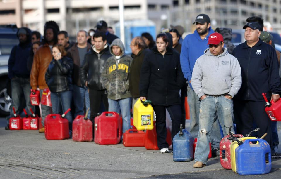 People line up at a gas station waiting to fill up, Friday, Nov. 2, 2012, in Newark, N.J. In parts of New York and New Jersey, drivers lined up early Friday for hours at gas stations that were struggling to stay supplied. The power outages and flooding caused by Superstorm Sandy have forced many gas stations to close and disrupted the flow of fuel from refineries to those stations that are open. (AP Photo/Julio Cortez)