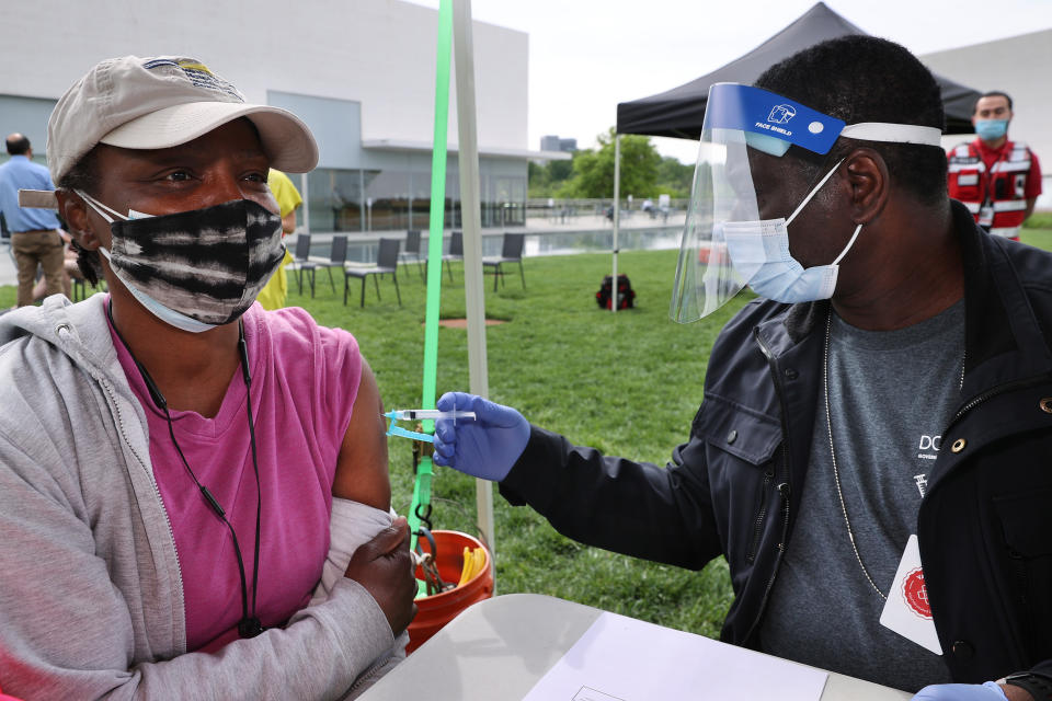 WASHINGTON, DC - MAY 06: Darlene Grant (L) receives a dose of the Johnson & Johnson coronavirus vaccine during a walk-up clinic at the Kennedy Center for the Performing Arts' outdoor Reach area on May 06, 2021 in Washington, DC. Hosted by the District of Columbia Health Department, the event also provided newly vaccinated people with a free beer courtesy of Solace Brewing Co. (Photo by Chip Somodevilla/Getty Images)