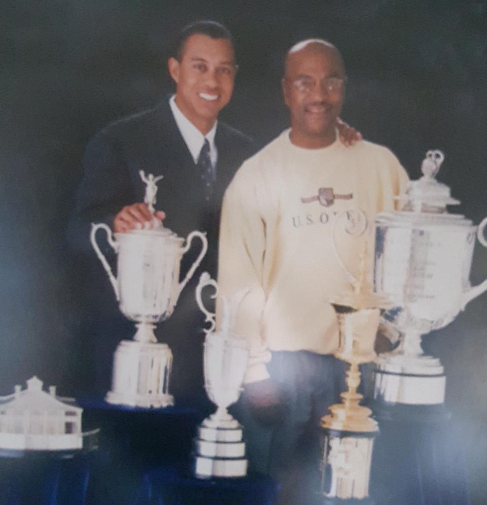 This is one of Pete McDaniel's treasured photos he has framed at his home. It's of him and Tiger Woods, with a few of Woods' trophies.