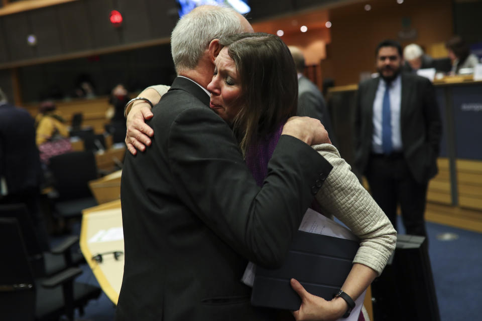 Scottish European Parliament member Aileen McLeod, right, hugs British European Parliament member Richard Corbett at the end of an European Parliament's constitutional affairs committee meeting for Brexit at the European Parliament in Brussels, Thursday, Jan. 23, 2020. Hours after the deal received royal assent from Queen Elizabeth II, an influential European Parliament's committee endorsed the withdrawal agreement, paving the way for Britain to leave the 28-country bloc next week. (AP Photo/Francisco Seco)