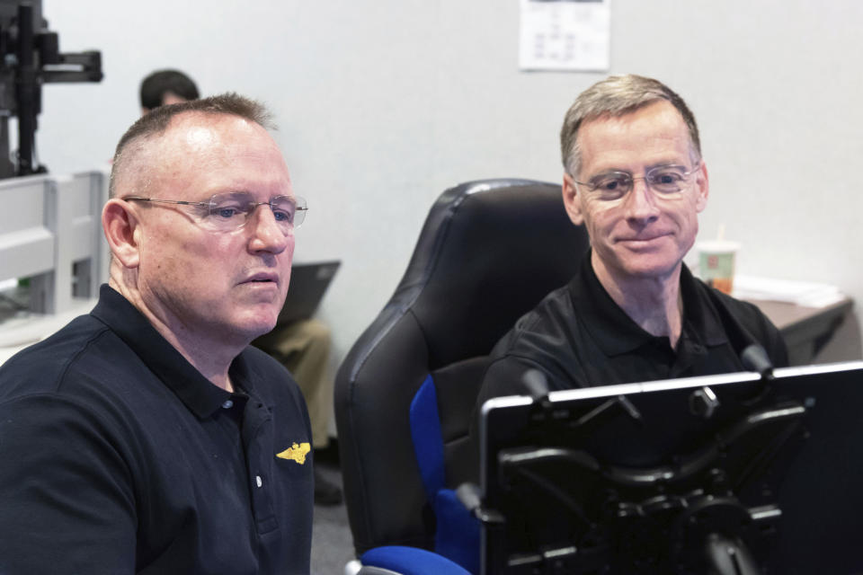 In this Nov. 29, 2018 photo made available by NASA, Commercial Crew Program & Boeing Crew Flight Test astronauts Butch Wilmore, left, and Chris Ferguson participate in a flight control simulation for a Boeing CST-100 Starliner capsule at the Johnson Space Center in Houston. On Wednesday, Oct. 7, 2020, Ferguson removed himself from the first Starliner crew, citing his daughter’s wedding in 2021. He has been replaced on the crew by Wilmore. (James Blair/NASA via AP)