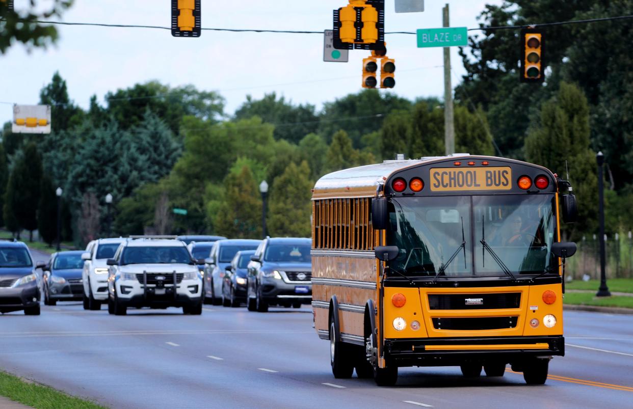 A school bus travels through a school zone at Blackman Elementary School along Fortress Blvd., on Tuesday, Aug. 9, 2022, as a Rutherford County Sheriff's vehicle waits to cross over Blaze Dr.