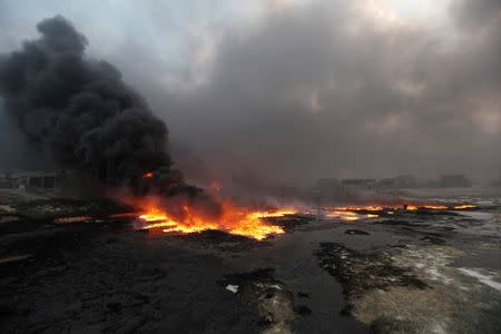 Fire rises from oil wells, set ablaze by Islamic State militants before fleeing the oil-producing region of Qayyara, Iraq, which has been recaptured by Iraqi forces, August 29, 2016. REUTERS/Azad Lashkari