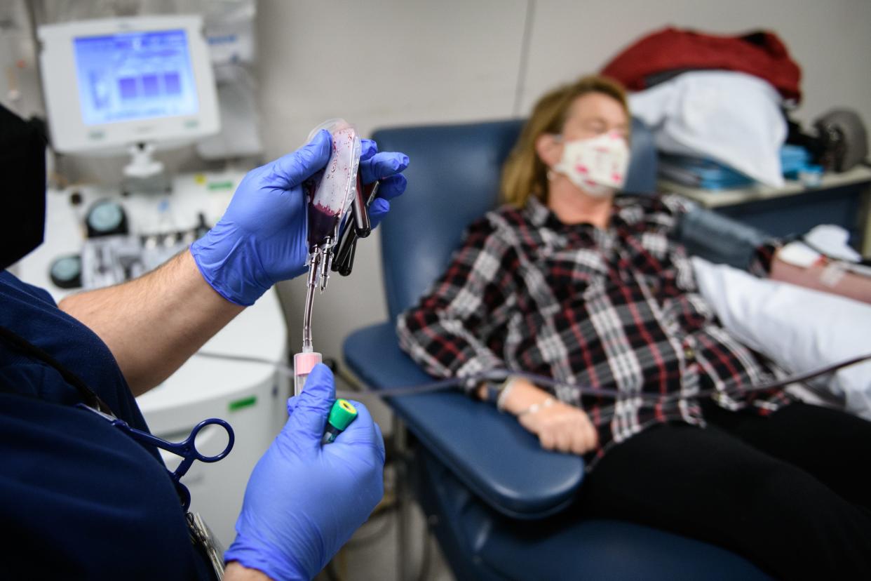 Phlebotomist Christina Clark, left, fills a few vials of blood from Chris Malloy as Malloy sits back and donates platelets at Cape Fear Valley Blood Donor Center on Tuesday, Dec. 7, 2021.