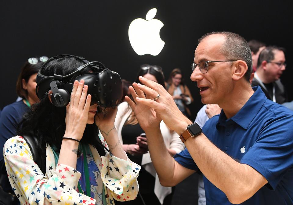 An Apple employee helps a member of the media try on an HTC Vive while testing the virtual reality capabilities of the new iMac during Apple's Worldwide Developers Conference in San Jose, California on June 5, 2017. / AFP PHOTO / Josh Edelson        (Photo credit should read JOSH EDELSON/AFP via Getty Images)